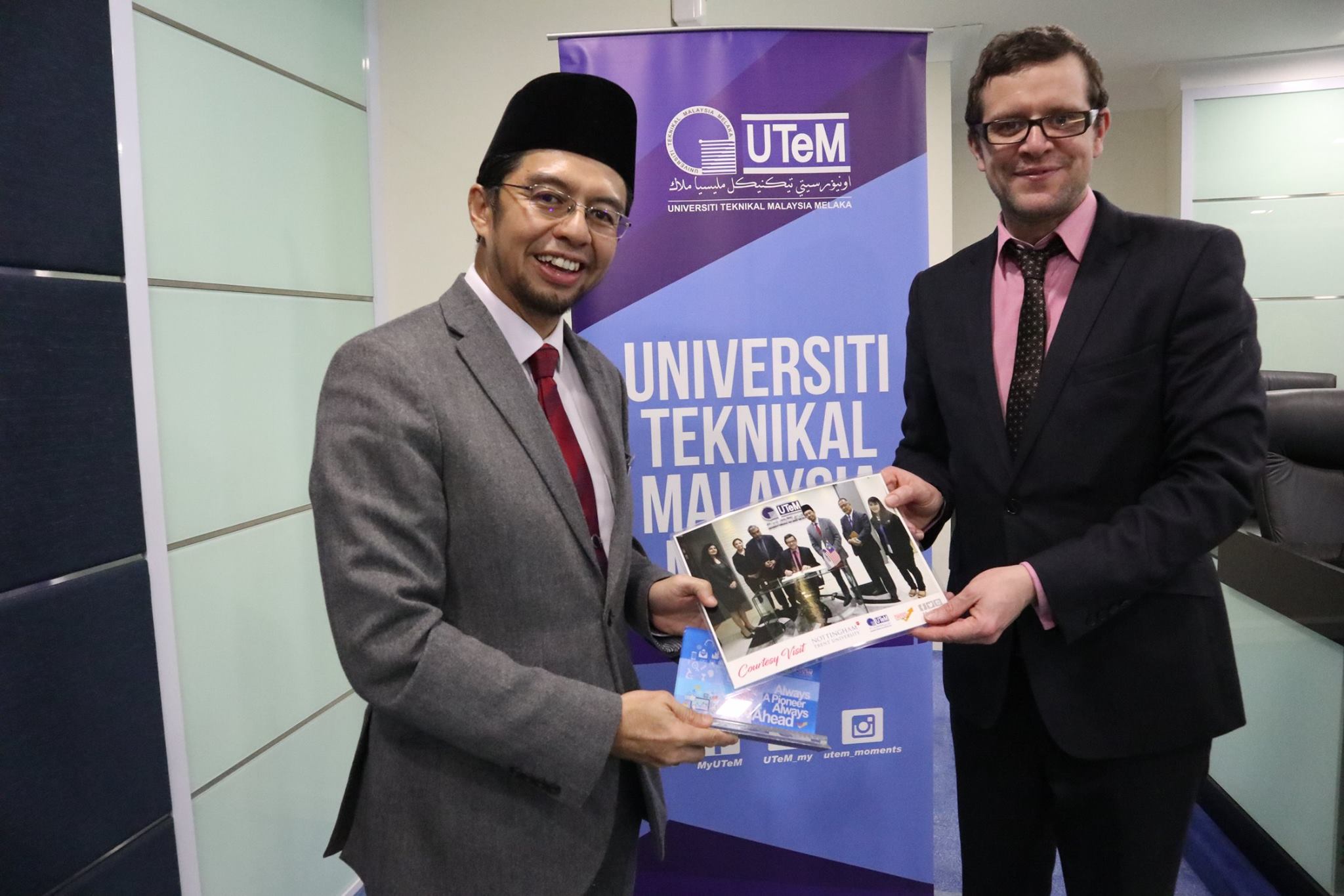 Naib Canselor UTeM menyerahkan gambar sebagai kenang-kenangan sewaktu ketua delegasi NTU, Dr. Jason Pandya Woods  menandatangi buku pelawat.